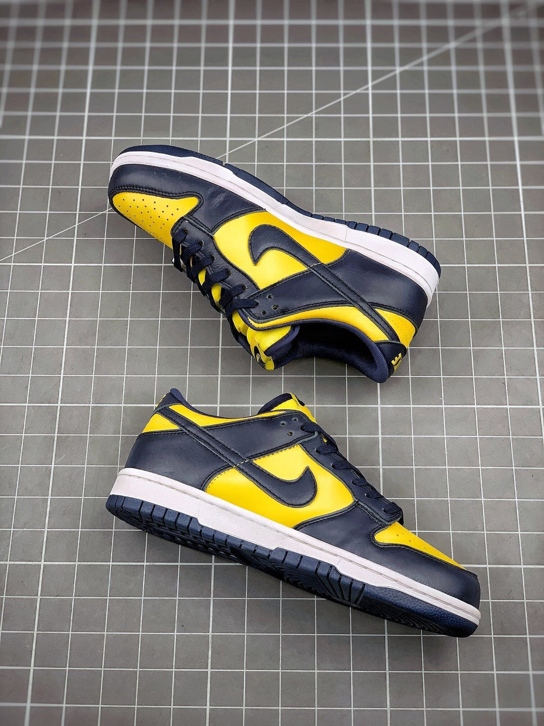 NIKE DUNK LOW "MICHIGAN" : Nike Dunk Low 'Michigan' sneaker featuring Varsity Maize leather upper with Midnight Navy overlays a